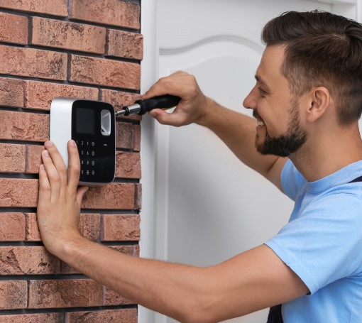stock-photo-male-technician-installing-alarm-system-indoors-1119181658
